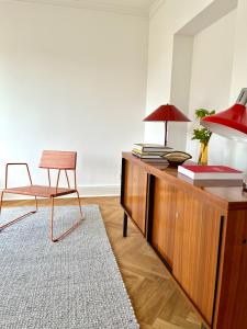 um quarto com uma secretária com uma cadeira e um candeeiro em WELL Pretty Places - sustainable interior design in the Citycenter em Kassel