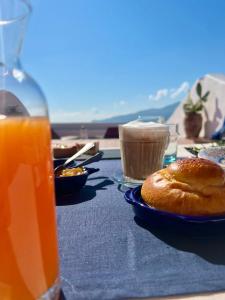 un tavolo con un piatto di cibo e un bicchiere di succo d'arancia di ANTICA DIMORA Santa Marina Salina a Santa Marina Salina
