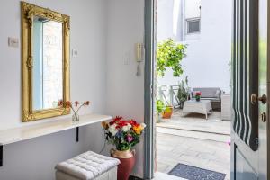 a living room with a mirror and a vase of flowers at Marialena Rooms in Skopelos Town