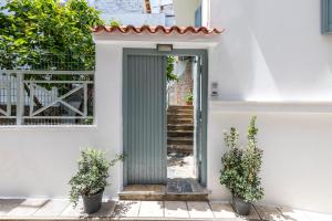 a green door in a white building with stairs at Marialena Rooms in Skopelos Town +29 photos