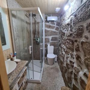 un bagno con doccia in vetro e WC di Isatour - Casa do Miradouro a Adsamo