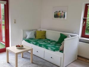 ein weißes Bett mit Kissen und einem Tisch im Zimmer in der Unterkunft Charmante Einliegerwohnung in Kiel