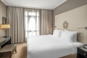 a hotel room with a large bed and a large window at Shahd Al Madina Managed by Accor in Al Madinah