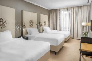 a hotel room with two beds and two lamps at Shahd Al Madina Managed by Accor in Al Madinah