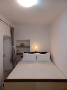 a bedroom with a white bed with a light on the ceiling at Milea in Makarska