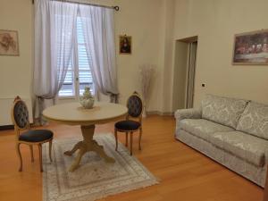 ein Wohnzimmer mit einem Tisch, Stühlen und einem Sofa in der Unterkunft Villa La Grotta in San Giustino Valdarno