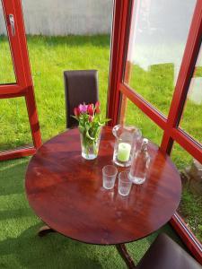 einen Holztisch mit einer Blumenvase darauf in der Unterkunft Charmante Einliegerwohnung in Kiel