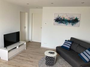 a living room with a couch and a flat screen tv at Casa Cremer in Übach-Palenberg