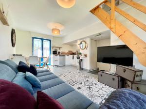 sala de estar con sofá azul y TV de pantalla plana en COC - La Brise Marine, en Wissant
