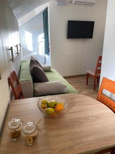 a room with a table with a bowl of fruit on it at Milea in Makarska