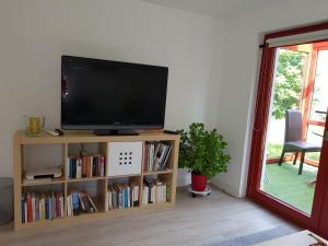 einen Flachbild-TV auf einem Bücherregal in der Unterkunft Charmante Einliegerwohnung in Kiel
