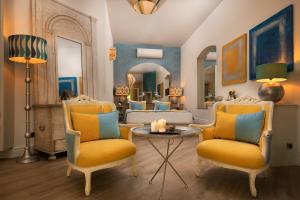 a living room with yellow chairs and a mirror at La Capria Suite Hotel Alacati in Alaçatı