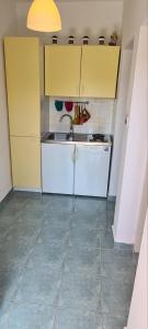 a kitchen with yellow cabinets and a sink at Apartments Porat in Porat