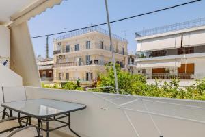 a balcony with a table and a building at Holiday Apartment Glyfada in Athens