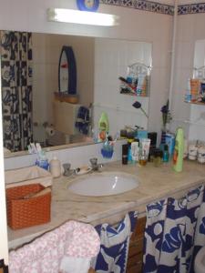 a bathroom counter with a sink and a mirror at Tamatramas in Albufeira