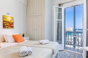 a bedroom with two beds and a balcony at Marialena Rooms in Skopelos Town