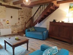 uma sala de estar com um sofá azul e uma mesa em La maison d'iréne em Soturac