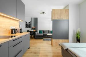 a kitchen and a living room with a couch at Apartament Jarzębinowy z ogródkiem in Łódź +10 photos