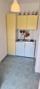 a small kitchen with white cabinets and a sink at Apartments Porat in Porat +15 photos