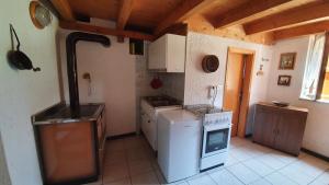 a small kitchen with a stove and a refrigerator at Baita di montagna Stavel in Vermiglio