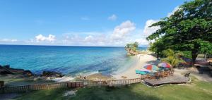 una playa con sombrillas y sillas en la playa en 1peace beach resort, en Anda