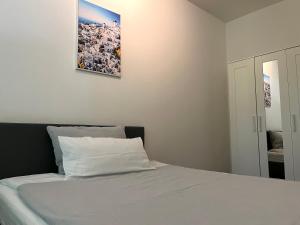 a bedroom with a white bed with a picture on the wall at NorthApartments Chemnitz in Chemnitz