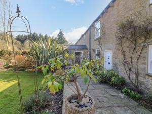 a garden in front of a house with a tree at Easby Cottage in Richmond