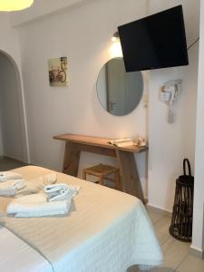 a room with a bed with a mirror and a television at Asteras in Antiparos