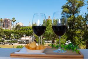 two glasses of red wine on a table with bread at Anime Bed&Breakfast in Syracuse