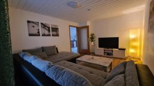 sala de estar con sofá y TV en Ferienwohnung-Kormann en Schkopau