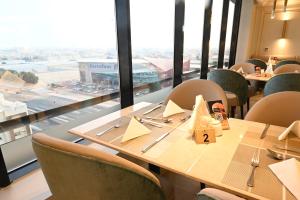 a restaurant with tables and chairs and large windows at Platinum Seventy in Jeddah