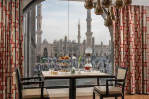 a table in a room with a view of a mosque at Sofitel Shahd Al Madinah in Al Madinah