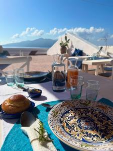 einen Tisch mit Teller mit Lebensmitteln und Gläsern darauf in der Unterkunft ANTICA DIMORA Santa Marina Salina in Santa Marina Salina