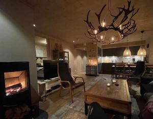 a living room with a fireplace and a living room with a table at Gaustatoppen Lodge - Mountain View - Gaustablikk in Rjukan