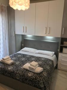 a bedroom with a large bed with towels on it at Planeta Scalea in Scalea
