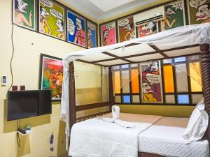 a bedroom with two beds and a tv in it at Omah Eling Medang Kamulan Borobudur in Borobudur +4 photos