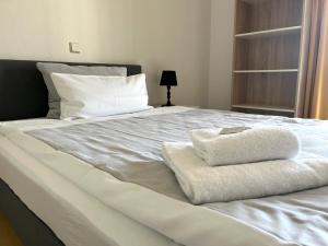 a white bed with two towels on it at NorthApartments Dresden in Dresden