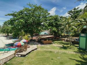 a resort with a pool and tables and umbrellas at 1peace beach resort in Anda