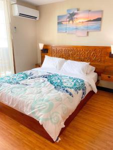 1 dormitorio con 1 cama grande y cabecero de madera en Bamboo 1002 condo, en Honolulu
