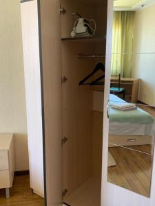 Habitación con dormitorio con cama y espejo. en Комфортабельная комната в квартире, en Astana