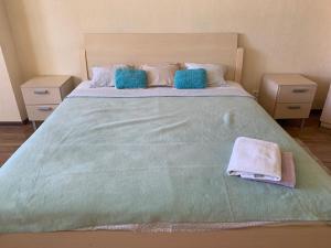 a large bed with two pillows and towels on it at Комфортабельная комната в квартире in Astana