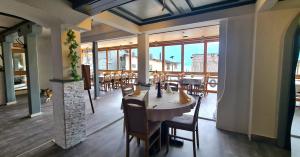 a dining room with a table and chairs and windows at Hotel Rössli in Oberried