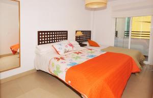 a bedroom with a bed with an orange blanket at 3 Bedroom Townhouse Benahavis Village in Benahavís