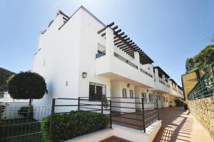 un edificio blanco con escaleras y una valla en 3 Bedroom Townhouse Benahavis Village en Benahavís