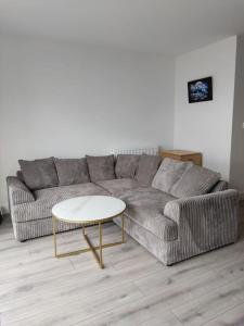een woonkamer met een bank en een tafel bij Modern apartment with breathtaking sea views in Penmaen-mawr