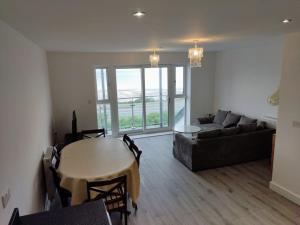 a living room with a table and a couch at Modern apartment with breathtaking sea views in Penmaen-mawr