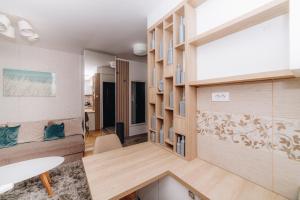 a living room with a desk and a dining room at Urban Lux Apartmani in Kragujevac
