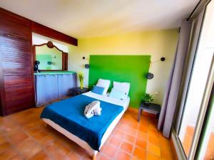 una camera da letto con un letto grande con testiera verde di Un petit coin de soleil au Paradis a La Trinité