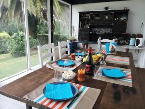 a dining room with a wooden table with blue napkins at maison et table d'hôtes Xori Kanta in Ascain +9 photos