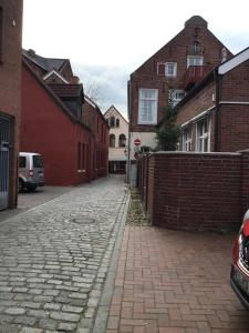 eine Kopfsteinpflasterstraße in einer Stadt mit Gebäuden in der Unterkunft Altstadtliebe in Leer